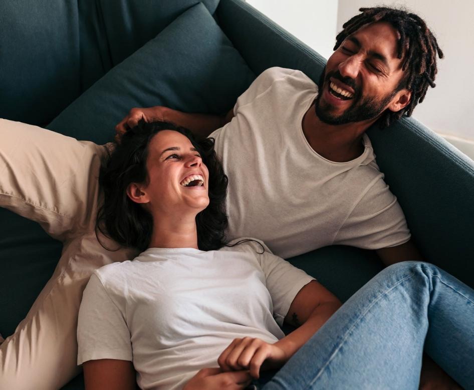 Couple laying on the couch laughing