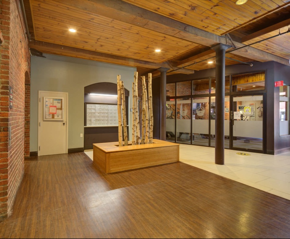 large lobby with exposed brink walls and old style wood flooring