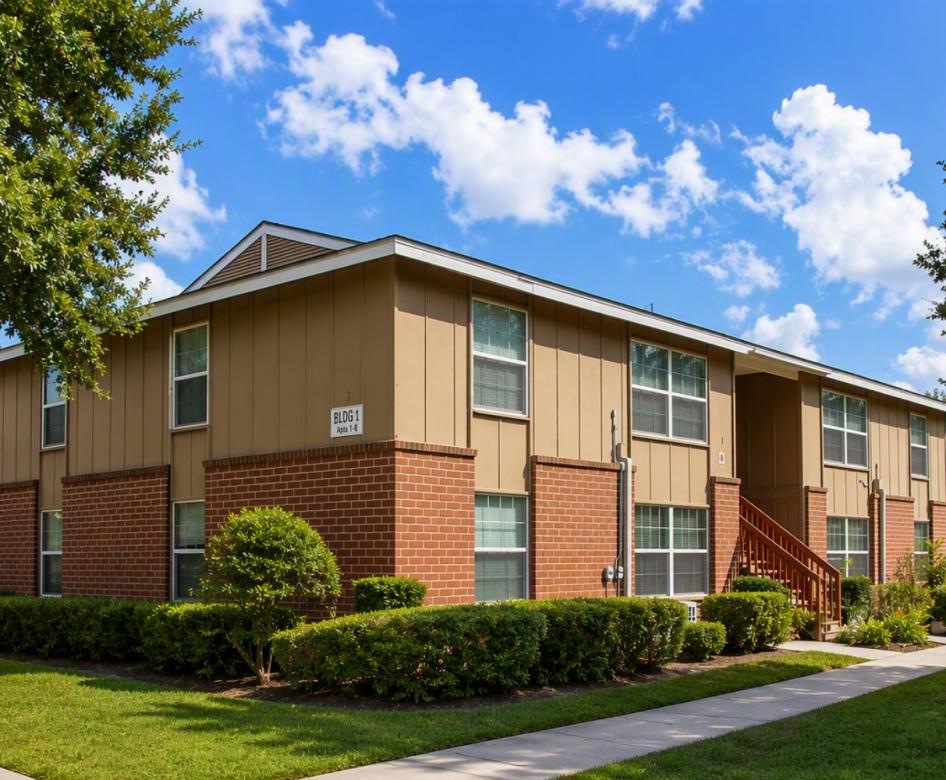 a brick building with trees and bushes