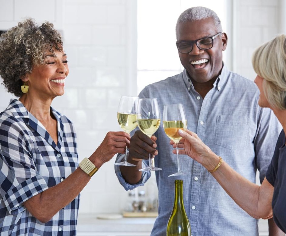 Group of people in a kitchen drinking wine
